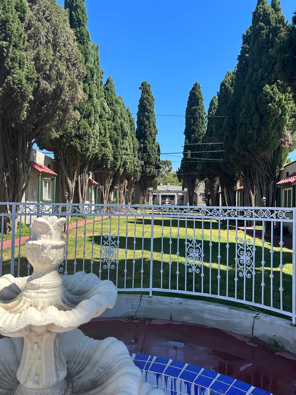 a fountain in front of a pond in a garden