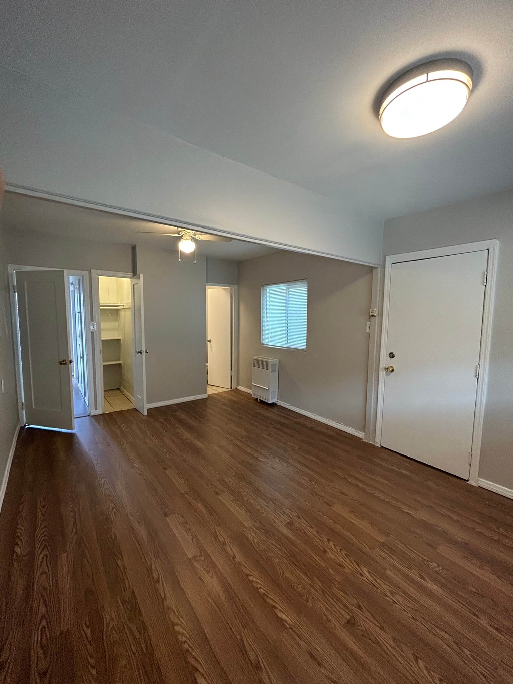an empty living room with wood flooring and white walls