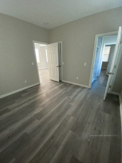 a living room with a wooden floor and a door