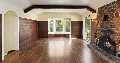 a empty living room with a stone fireplace