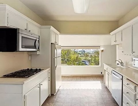 a white kitchen with a stove and a microwave