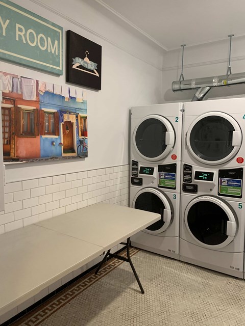 A laundromat with a row of washers and a bench.