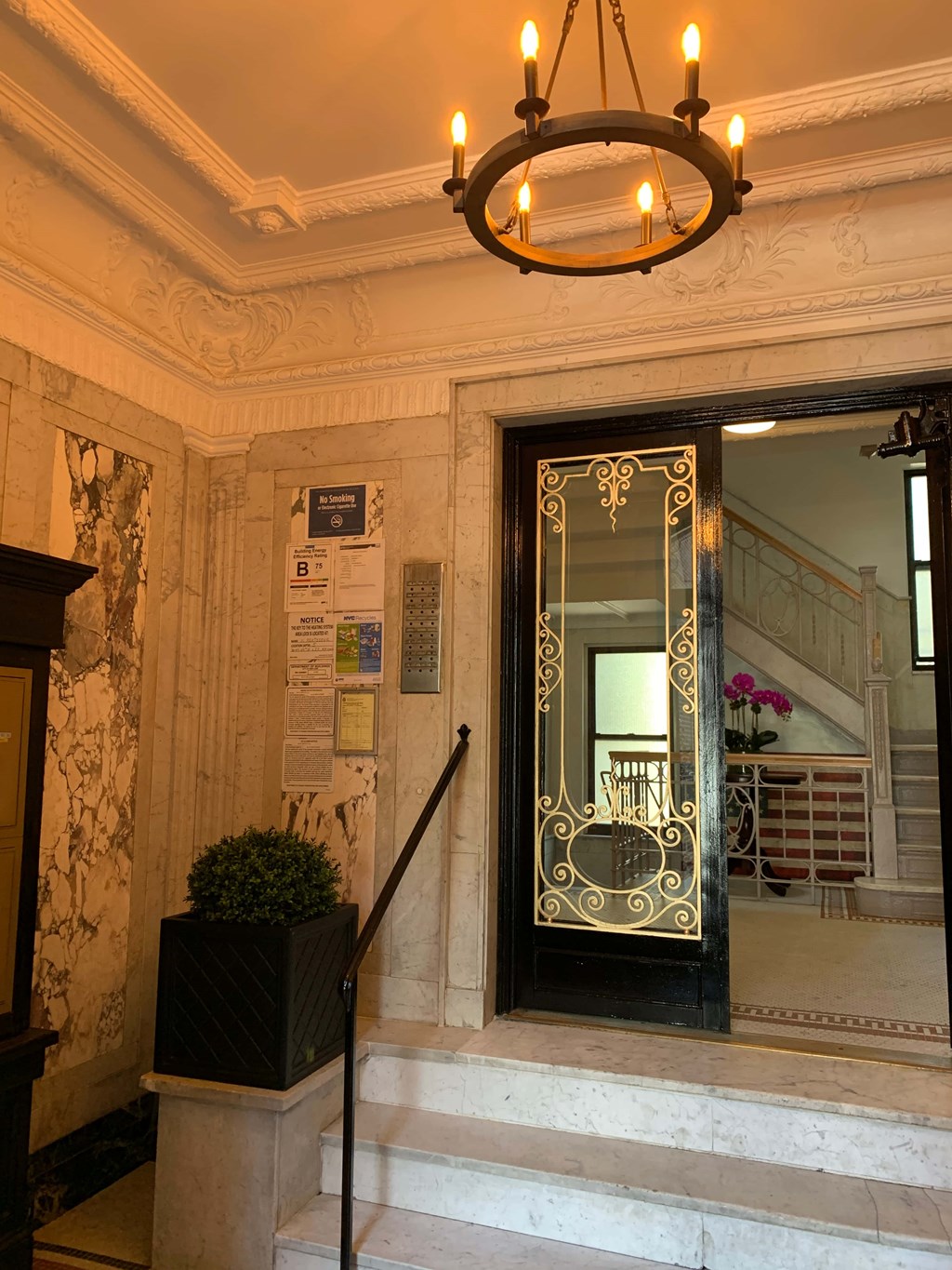 a view of the front door of a building with stairs and a mirror