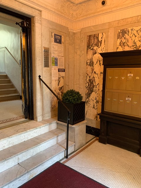 A staircase with a red carpet in front of it.