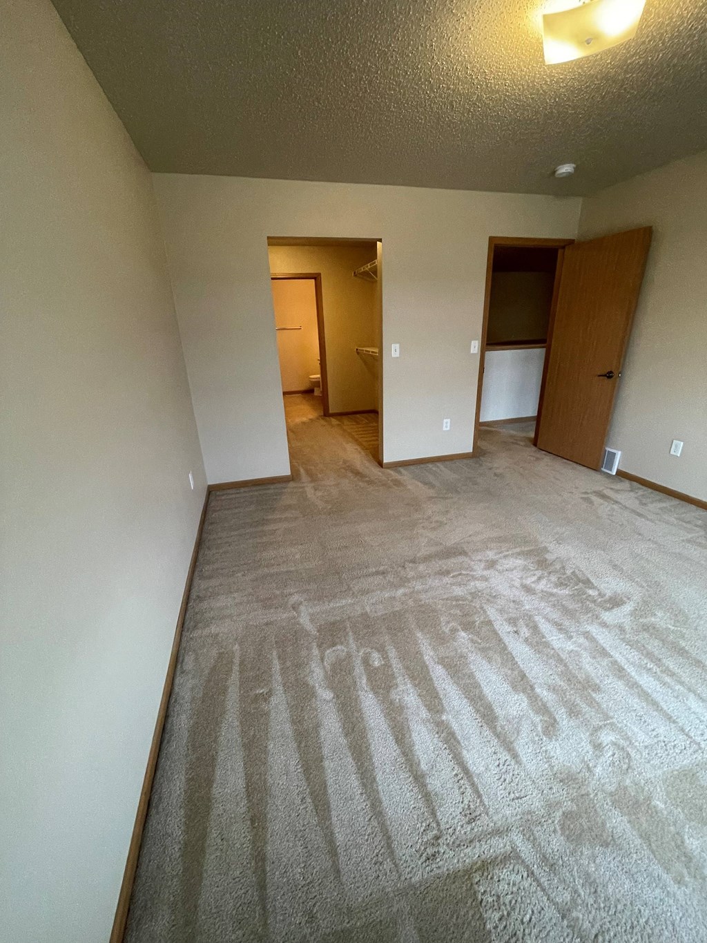 the living room of an empty apartment with a carpeted floor