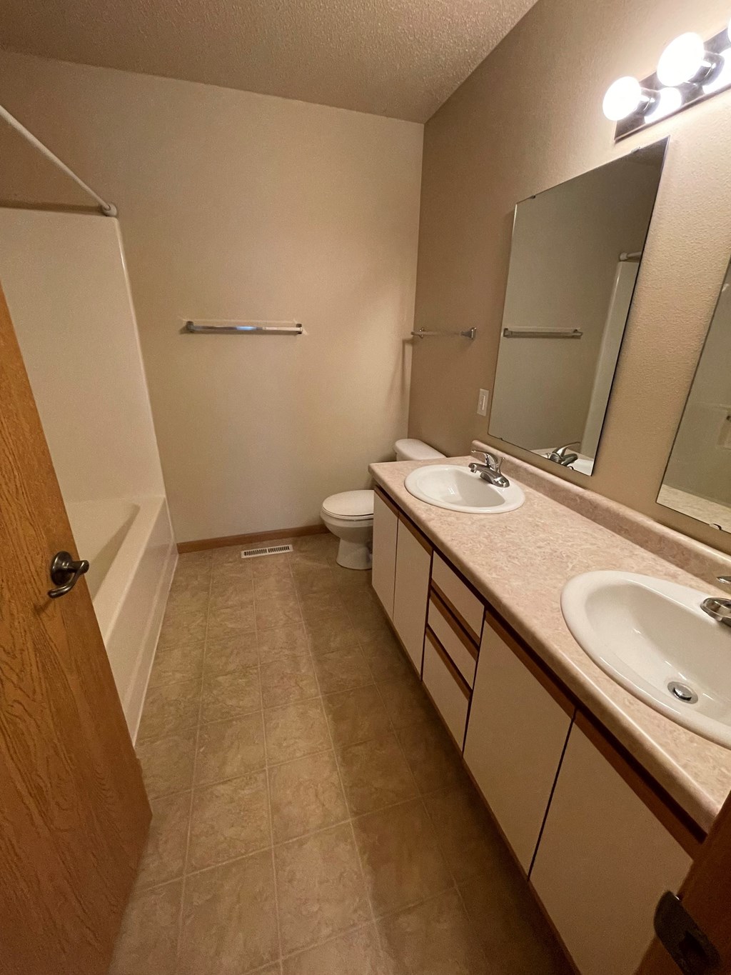 a bathroom with two sinks and a shower and a toilet
