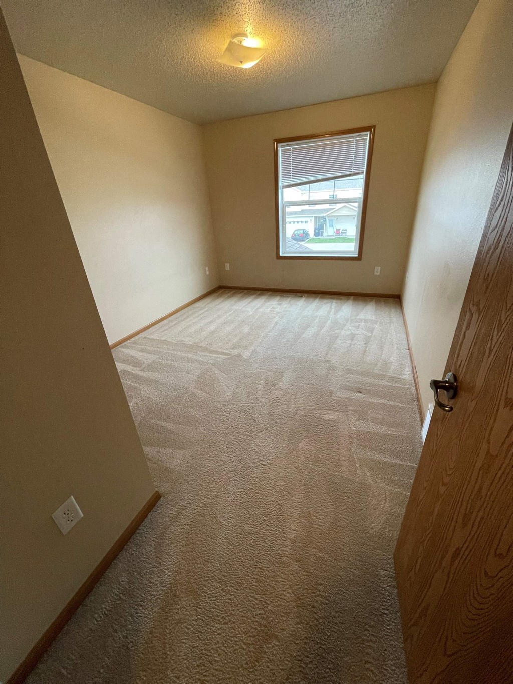 an empty room with a window and a door