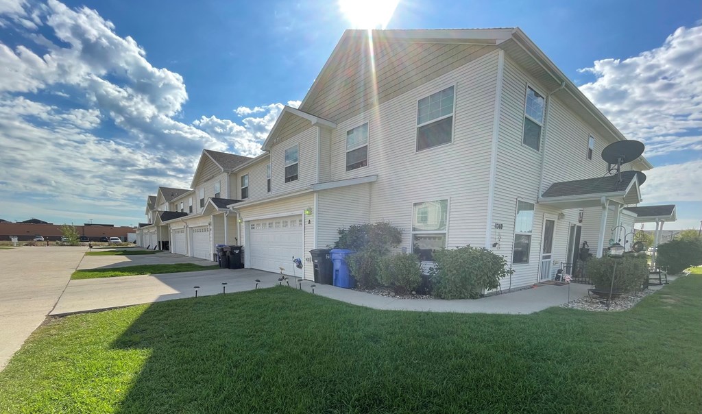 a white house with a sidewalk and grass in front of it