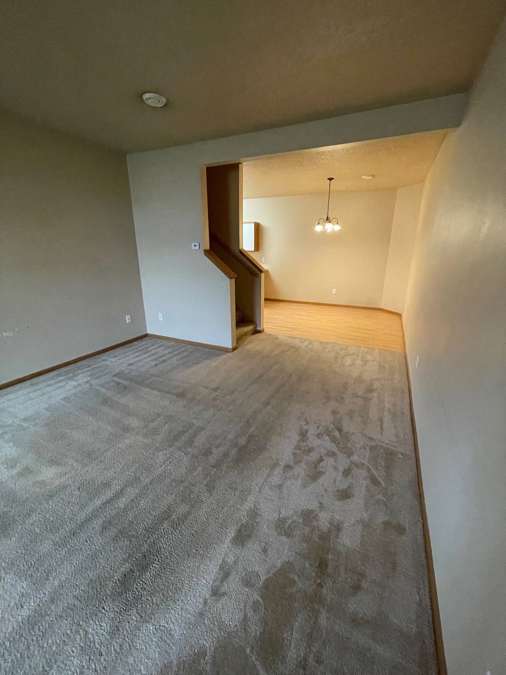 the living room and dining room of an empty apartment