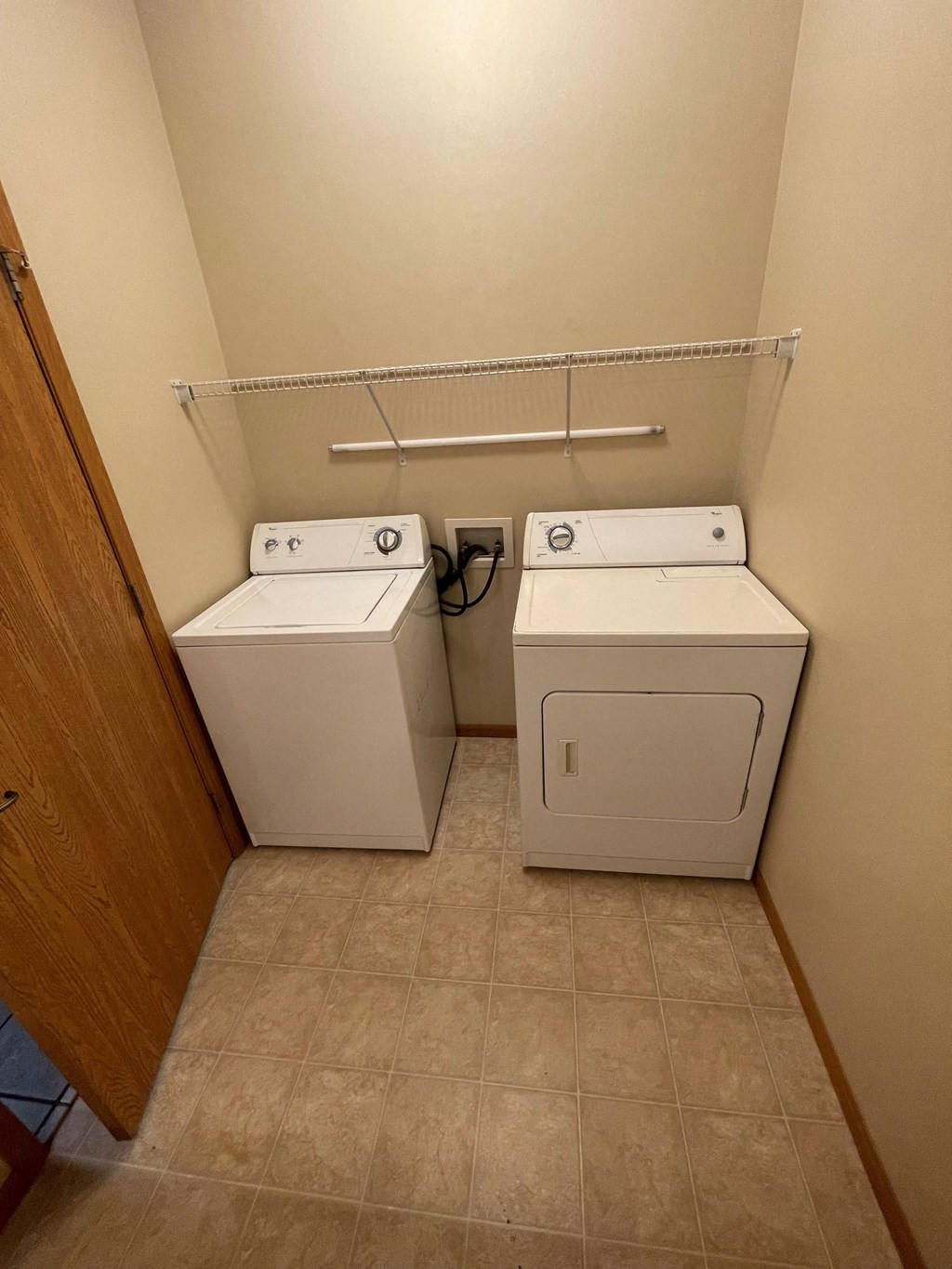 two washers and dryers in a room with a door