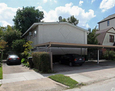 a garage with two cars parked in front of a house