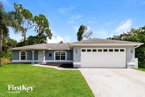 a blue house with a lawn and a white garage door