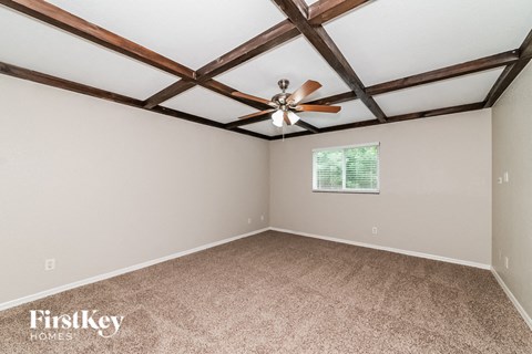 a living room with a ceiling fan and carpet