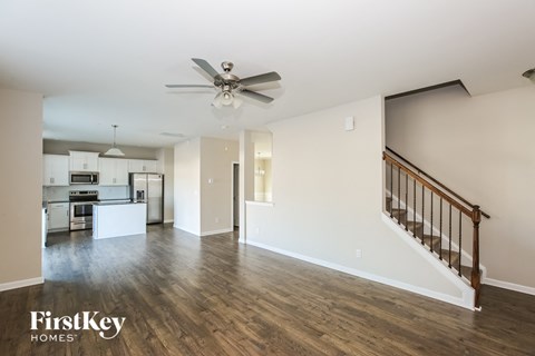 A spacious living room with a staircase leading to the upper floor.