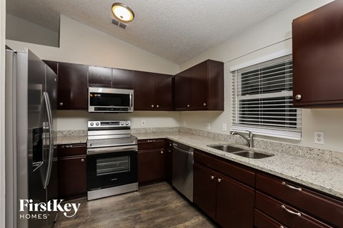 full kitchen with dark cabinets and granite counter tops and stainless steel appliances