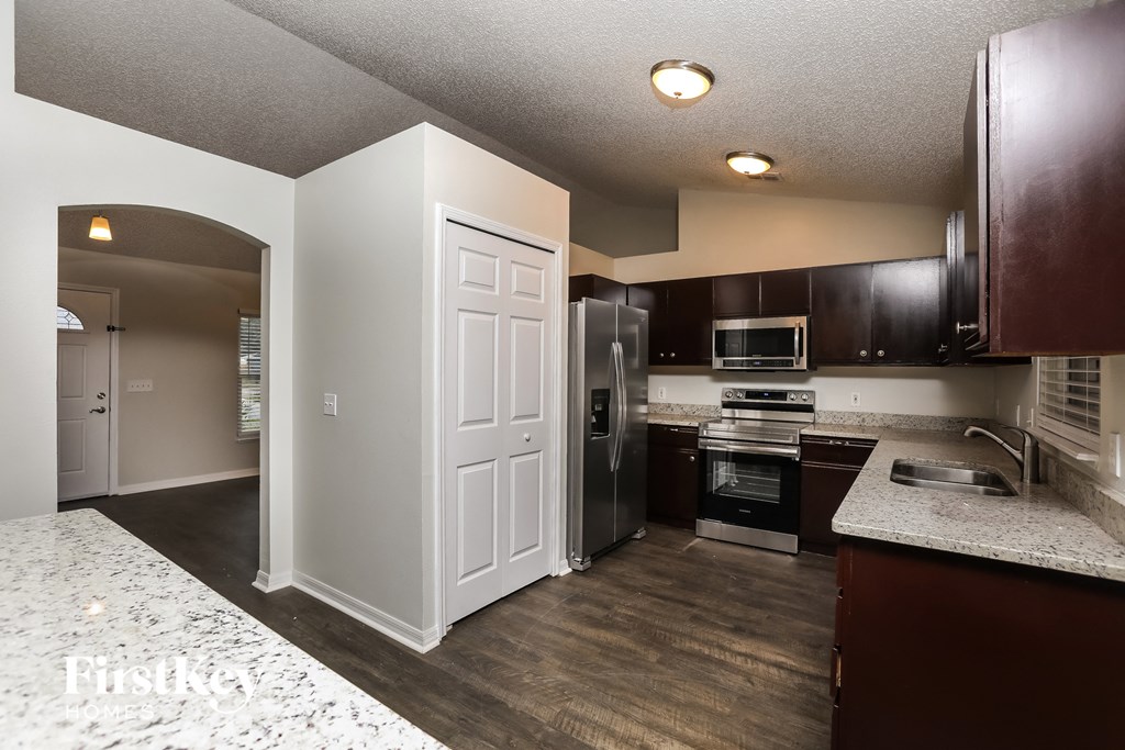 a kitchen with black and white cabinets and a stainless steel refrigerator