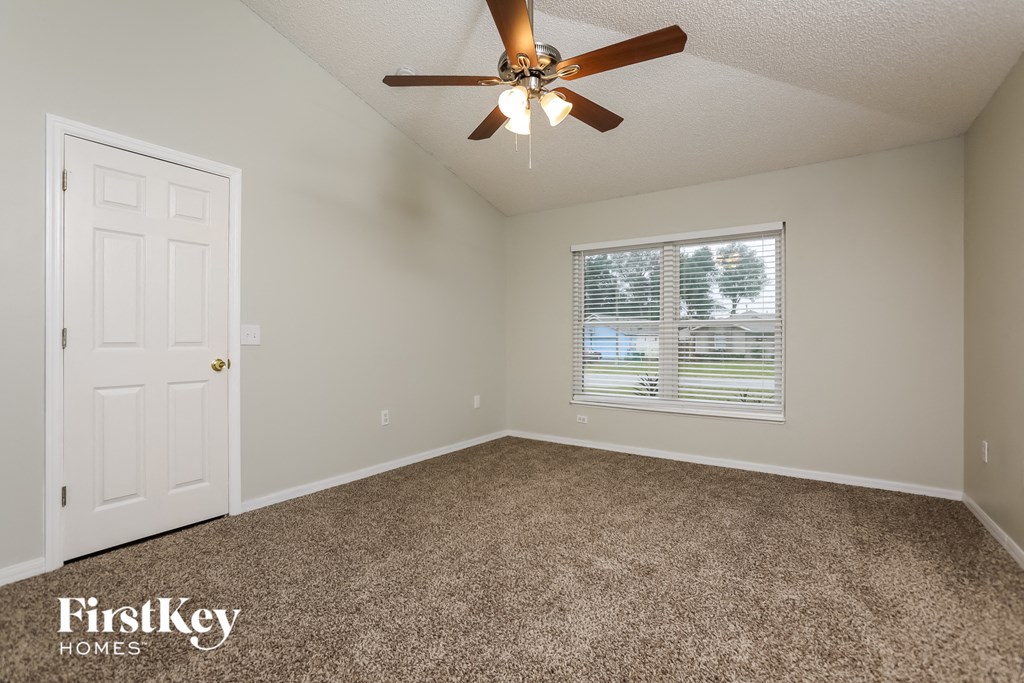 the master bedroom has a ceiling fan and a window