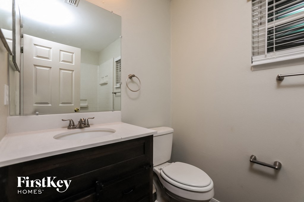 a bathroom with a sink toilet and a mirror
