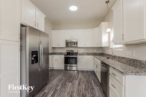 a kitchen with white cabinets and stainless steel appliances