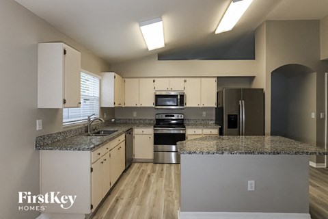 a kitchen with granite counter tops and stainless steel appliances