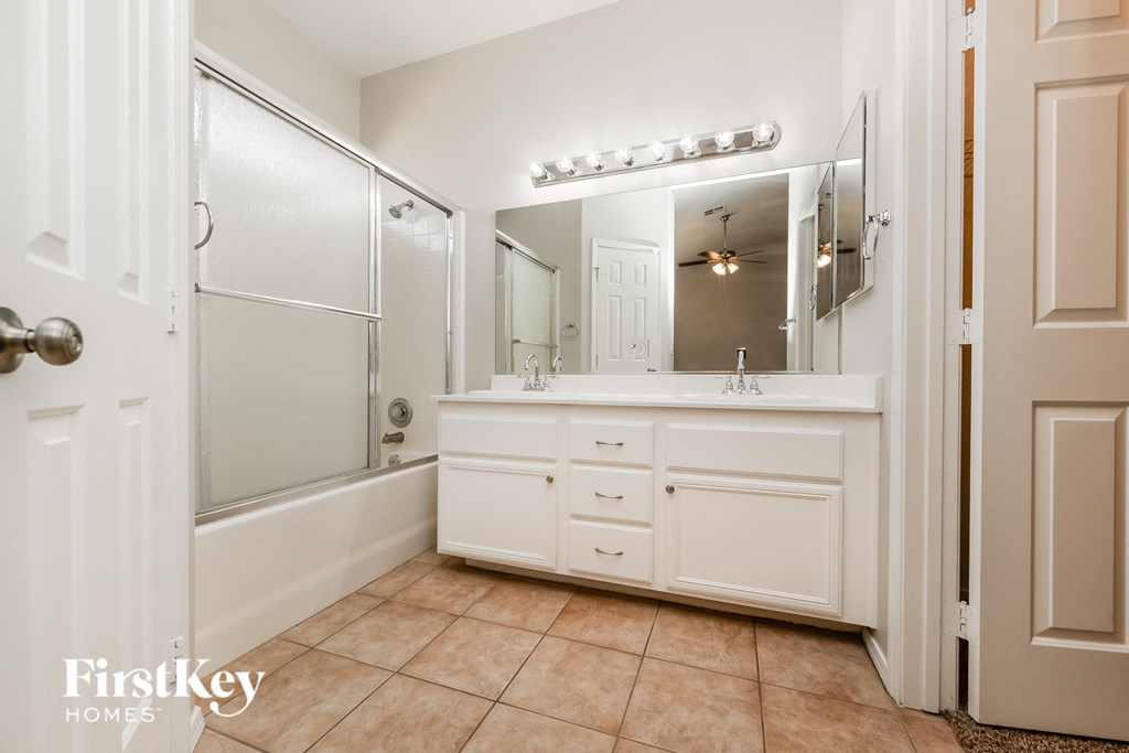 a bathroom with a sink and a shower and a mirror