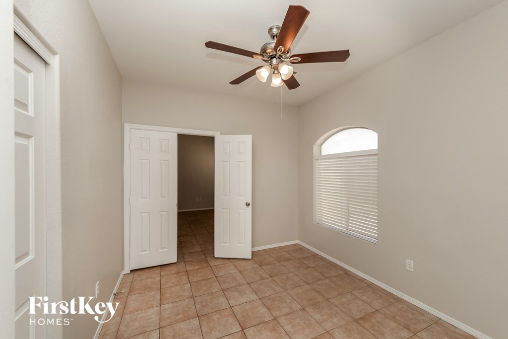 the living room has a ceiling fan and tile flooring