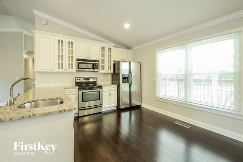 a kitchen with white cabinets and stainless steel appliances