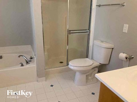 a white bathroom with a toilet and a shower