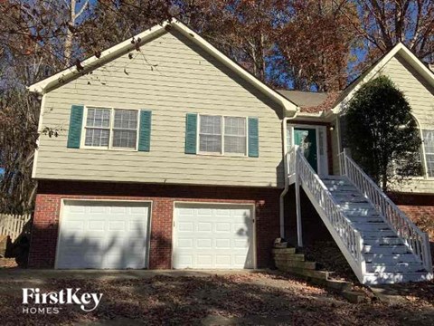a yellow house with two garage doors and a staircase