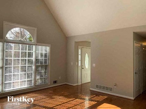 an empty living room with a large window and a door