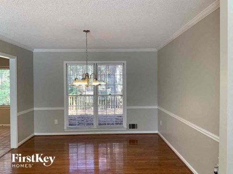 an empty living room with a large window and wooden floors