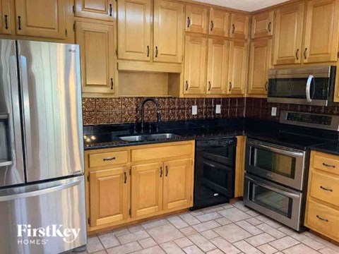 a kitchen with wooden cabinets and stainless steel appliances