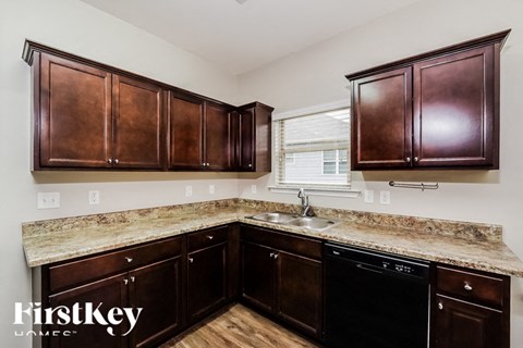 A kitchen with brown cabinets and a granite countertop.