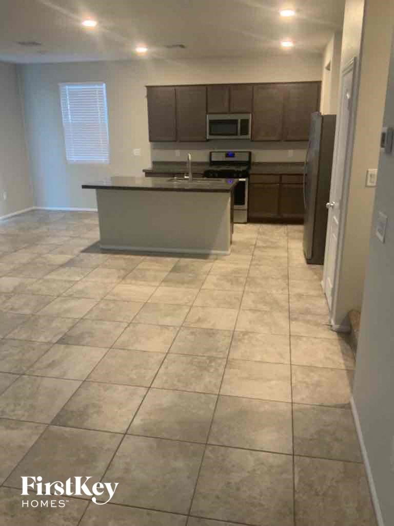an empty kitchen with tile flooring in a house