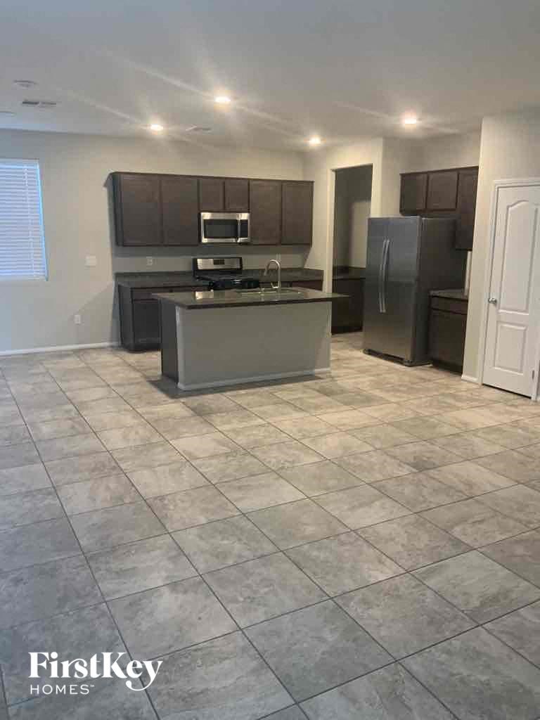 an empty kitchen with a sink and a refrigerator