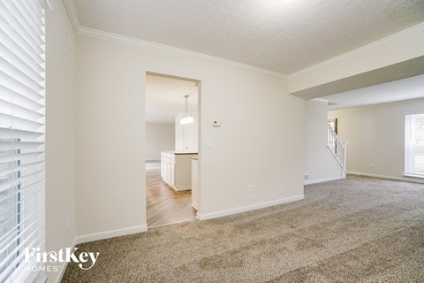 a living room with white walls and a carpeted floor