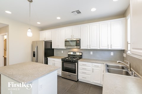 a kitchen with white cabinets and stainless steel appliances
