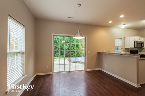 A well lit kitchen with a dining area outside.