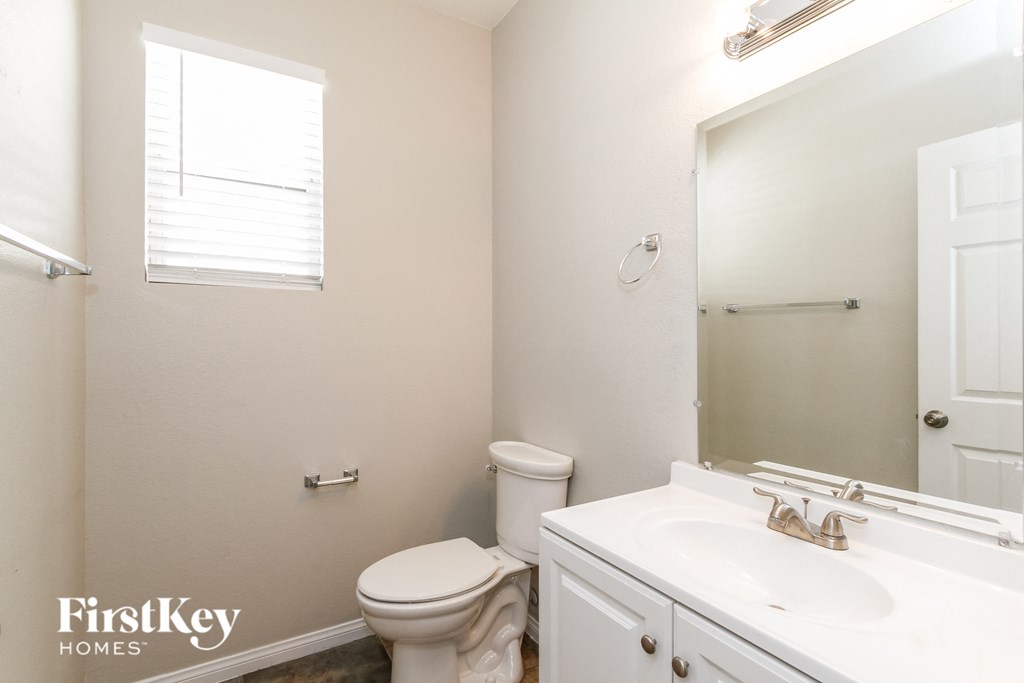 a bathroom with a toilet and a sink and a mirror