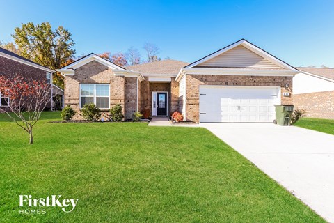 a brick house with a white garage door and a lawn