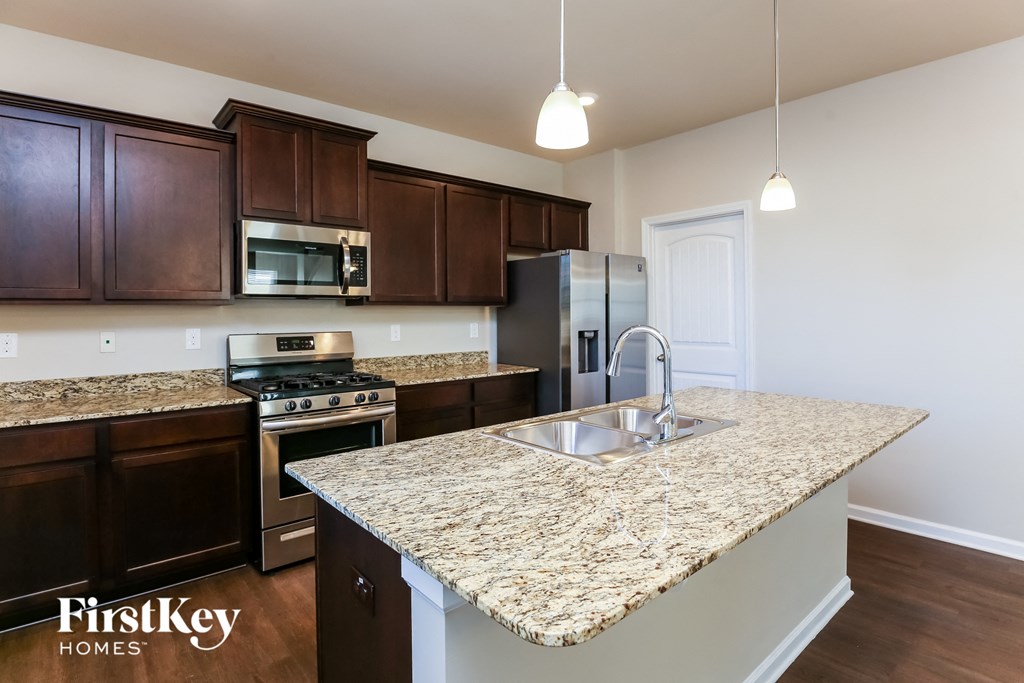 a kitchen with granite countertops and stainless steel appliances