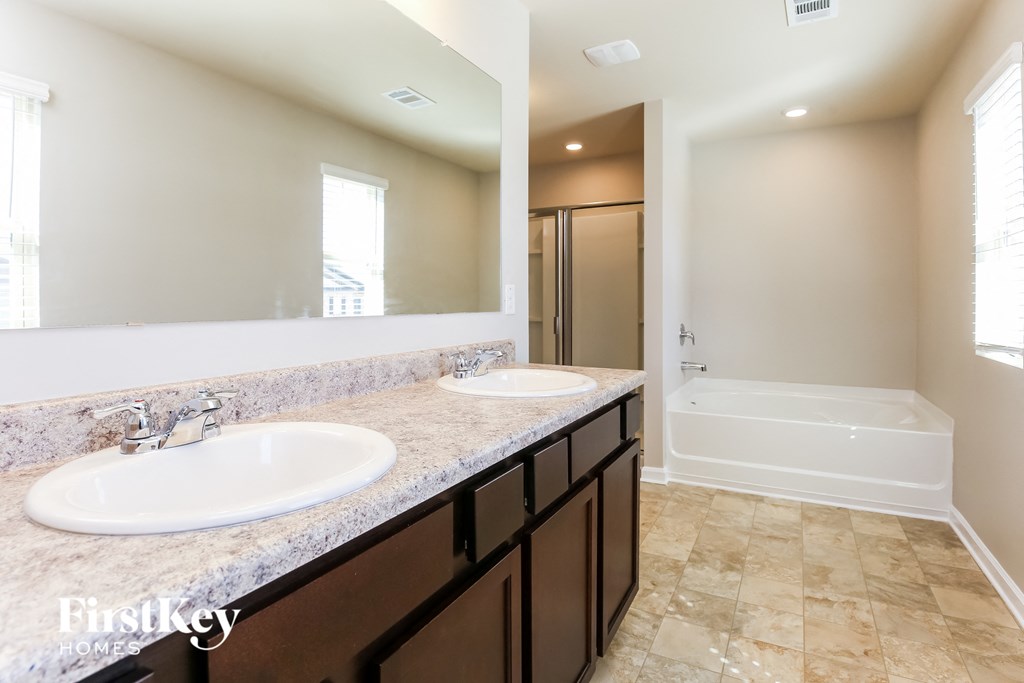 two sinks in a bathroom with a tub and a shower