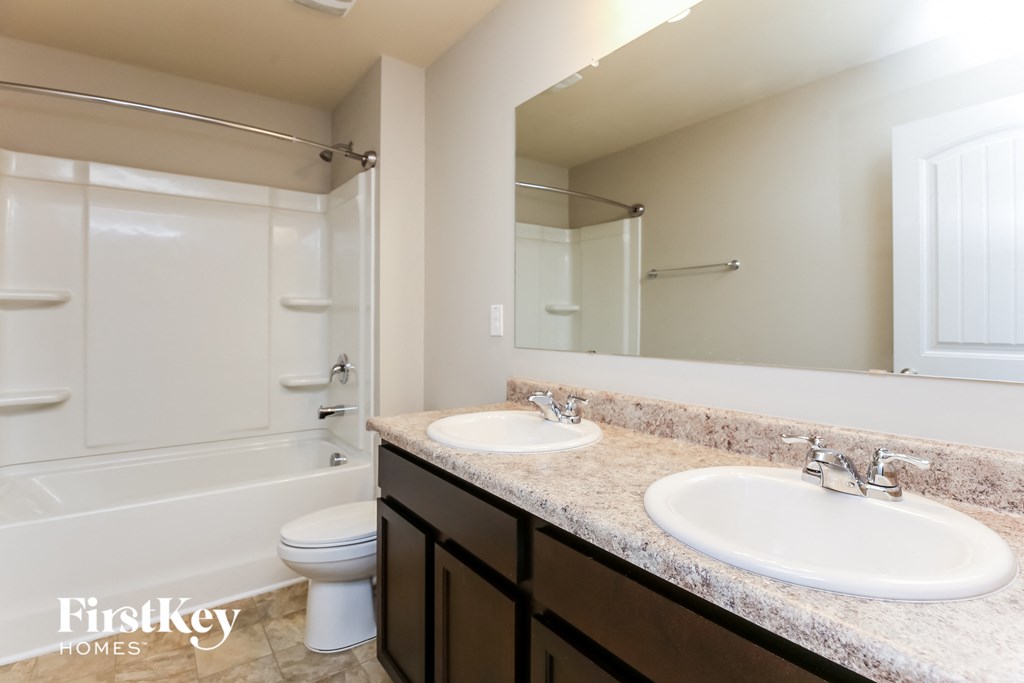 a bathroom with two sinks and a shower and a toilet