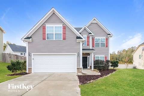 a single story home with gray siding and red shutters