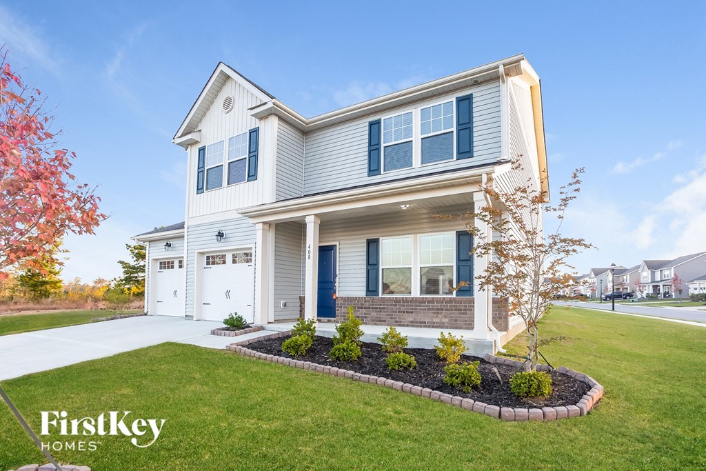 a white house with blue shutters and a front yard