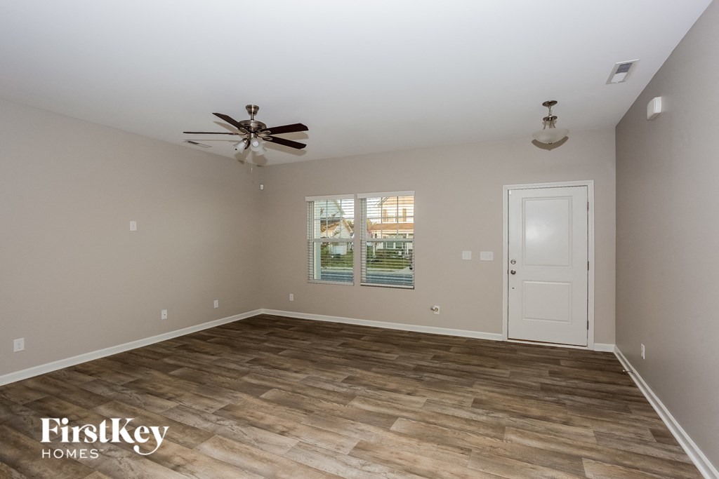 a living room with a ceiling fan and a white door