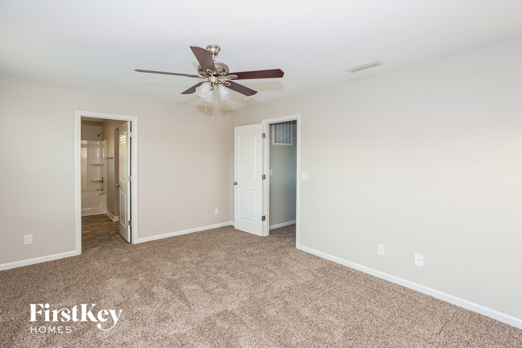 a living room with carpet and a ceiling fan