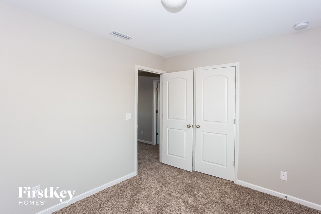a bedroom with two closet doors and a door to a hallway