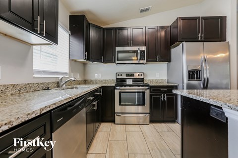 A kitchen with black cabinets and stainless steel appliances.