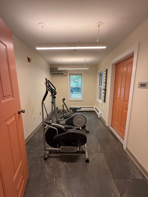 A gym room with a treadmill and exercise bike.